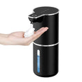 Automatic touchless soap dispenser in black dispensing foam soap into a hand for hygienic use.