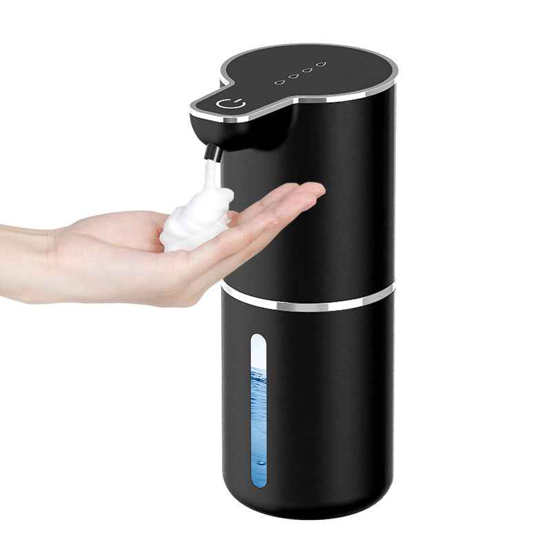 Automatic touchless soap dispenser in black dispensing foam soap into a hand for hygienic use.